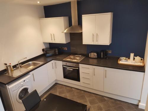 a kitchen with white cabinets and a sink and a dishwasher at Buller View in York
