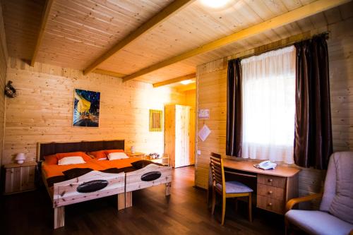 a bedroom with a bed and a desk in a room at Szatmár Beregi Élményliget in Fehérgyarmat
