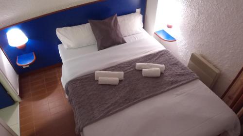 a bedroom with a large bed with two towels on it at VVF Belle-Île-en-Mer in Le Palais