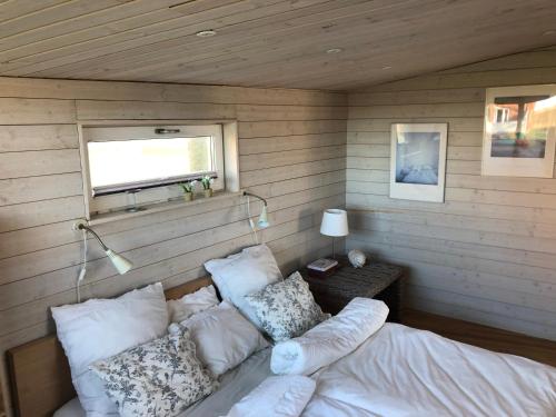 een kamer met een bed met kussens en een raam bij Villa Olympia in Höganäs