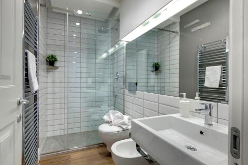 łazienka z umywalką, toaletą i lustrem w obiekcie Mattonaia Apartment by Mamo Florence we Florencji