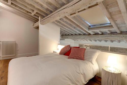 sypialnia z dużym białym łóżkiem z czerwonymi poduszkami w obiekcie Mamo Florence - Mattonaia Apartment we Florencji