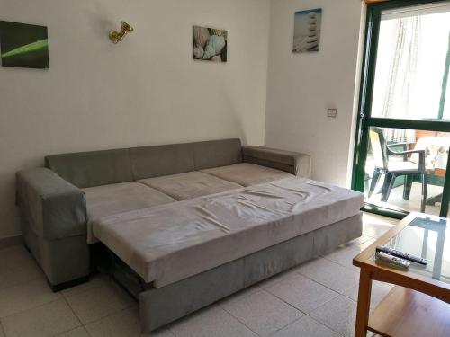 un grande letto in una stanza con tavolo di Apartamento Orla-Mar a Vila Nova de Cacela