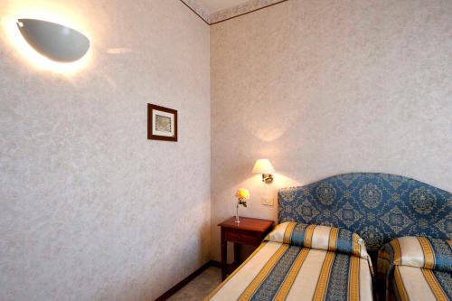 a bedroom with two beds and a table with a lamp at Hotel Moderno in Siena