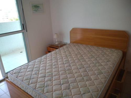 a bed in a bedroom with a window at 01 Quadra da Praia in Riviera de São Lourenço