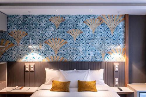 - une chambre dotée d'un lit avec du papier peint bleu et or dans l'établissement voco Strasbourg Centre - The Garden, an IHG Hotel, à Strasbourg