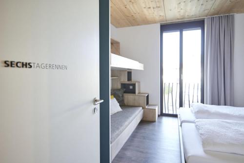 a room with a bed and a living room with a window at Radhotel am Gleis in Radolfzell am Bodensee