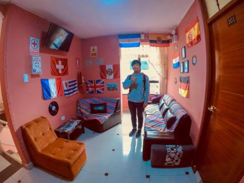 a man standing in a room with a living room at Hostal Berlin in Jauja