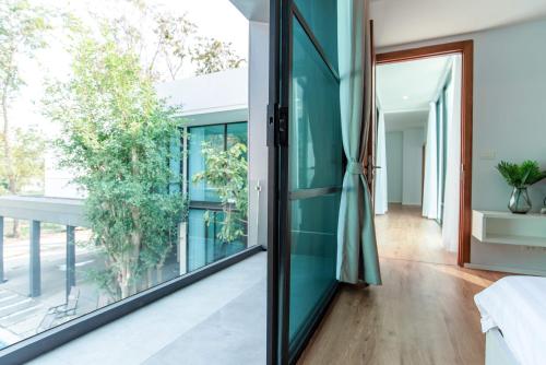 a room with a glass door leading to a balcony at Vmoon villa chiangmai in Chiang Mai