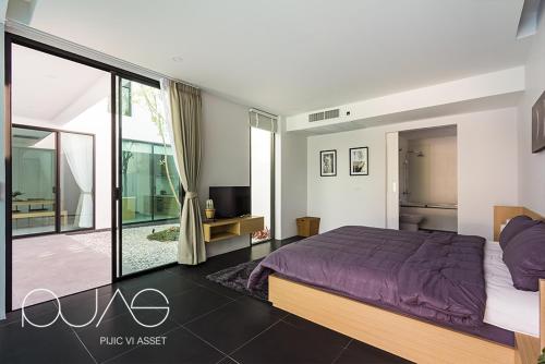 a bedroom with a purple bed and a balcony at Vmoon villa chiangmai in Chiang Mai