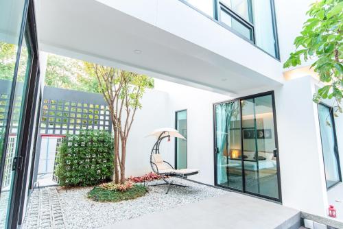 a room with glass doors and a chair on a patio at Vmoon villa chiangmai in Chiang Mai
