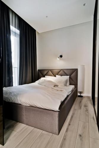 a bedroom with a large bed with white sheets at City Center Loft in Kaunas