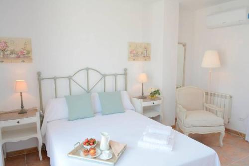 a bedroom with a bed with a tray of fruit on it at Domatsea Casa Provenzal in Hospitalet de l'Infant