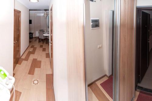 een hal die leidt naar een kamer met een deur en een houten vloer bij Apartment on Pozhyaki in Kiev