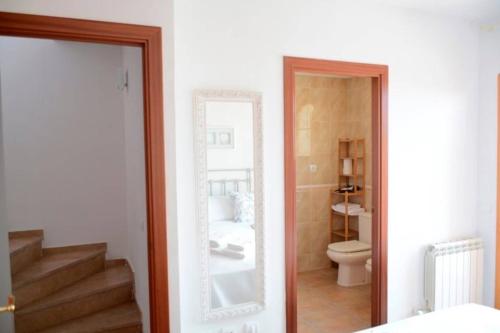 a bathroom with a toilet and a mirror and a staircase at Domatsea Casa Provenzal in Hospitalet de l'Infant