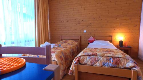 une chambre avec deux lits et une table et une fenêtre dans l'établissement VVF Lac de Serre-Ponçon, à Chorges