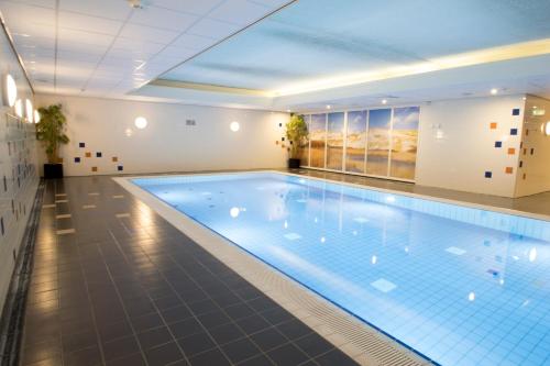 a large swimming pool in a hotel room at Résidence Terschelling in Midsland