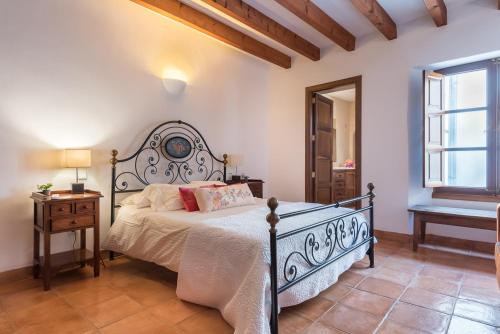 a bedroom with a bed and a table and a window at Ca S’angel in Biniaraix