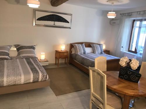 sypialnia z 2 łóżkami i drewnianym stołem w obiekcie Chambre Familiale du Couvent w mieście Narbona