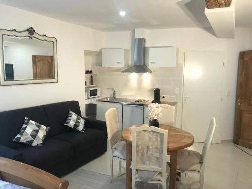 un salon avec un canapé noir et une table dans l'établissement Chambre Familiale du Couvent, à Narbonne