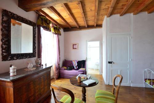 ein Wohnzimmer mit einem Tisch und einem Spiegel in der Unterkunft La Maison d'Anais in Vic-en-Bigorre