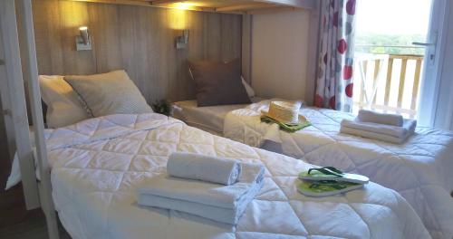 a bedroom with two beds with towels on them at VVF Vienne Poitou in La Bussière