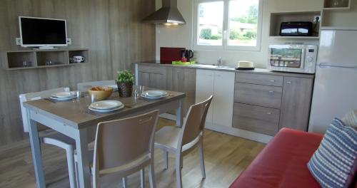 a kitchen with a table and chairs in a kitchen at VVF Vienne Poitou in La Bussière