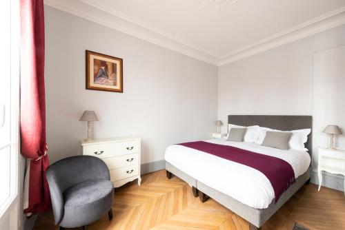 une chambre avec un lit et une chaise dans l'établissement Objectif Lune, à Paris