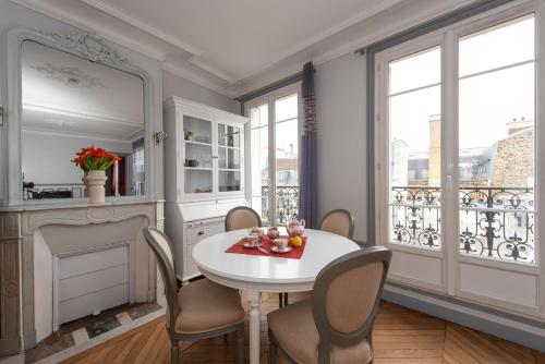 une salle à manger avec une table et des chaises et une cheminée dans l'établissement Objectif Lune, à Paris