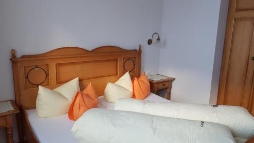 a bedroom with two beds with orange and white pillows at Apart-Garni Motnaida in Samnaun