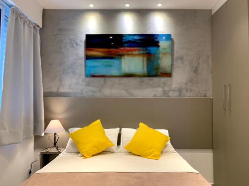 um quarto com uma cama com duas almofadas amarelas em The Best Apartment in Copacabana - Quarto e Sala no Rio de Janeiro
