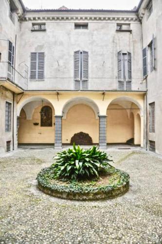 une grande maison avec un jardin en face de celle-ci dans l'établissement Two rooms apartment in Palazzo Malaspina, à Plaisance