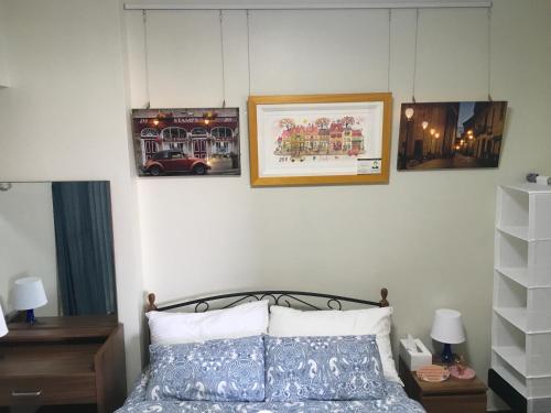 a bedroom with a bed and pictures on the wall at Viera Residence in Manila