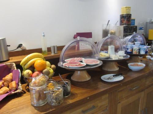 a kitchen counter with three plates of food and fruit at Logis Hôtel Château De Palaja in Carcassonne
