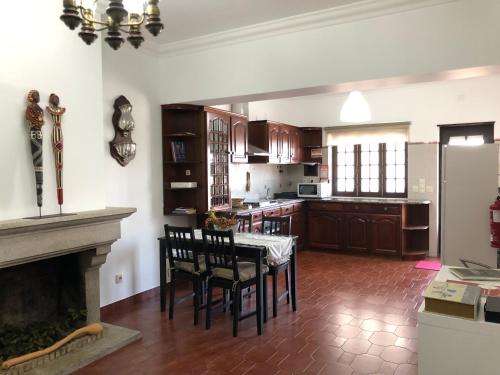 a kitchen with a table and chairs and a fireplace at Casa da Retorta in Alcains