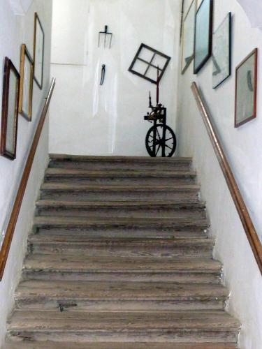 a stairway with a bicycle in a room with paintings at Schloss Berg Klösterle in Zedlitzdorf