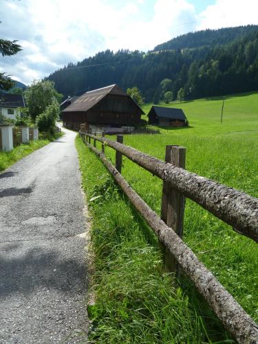 a wooden fence next to a field and a barn at Schloss Berg Klösterle in Zedlitzdorf