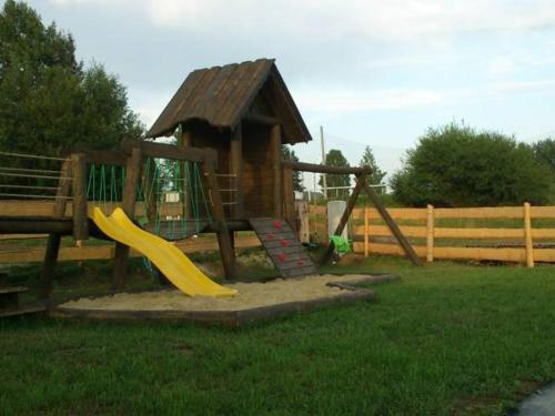 a playground with a slide and a play structure at Domki Pasja II in Kluszkowce