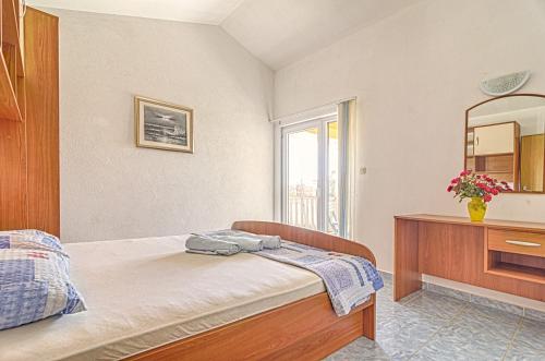 een slaapkamer met een bed, een dressoir en een spiegel bij Apartmani Marin in Medulin