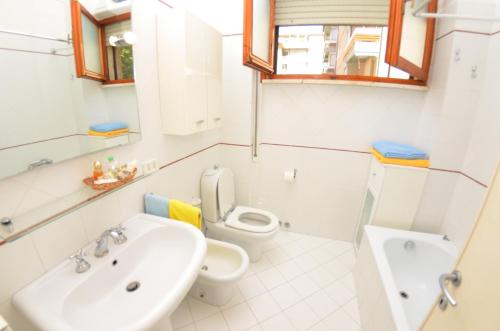 La salle de bains blanche est pourvue d'un lavabo et de toilettes. dans l'établissement Carnevale, à Viareggio