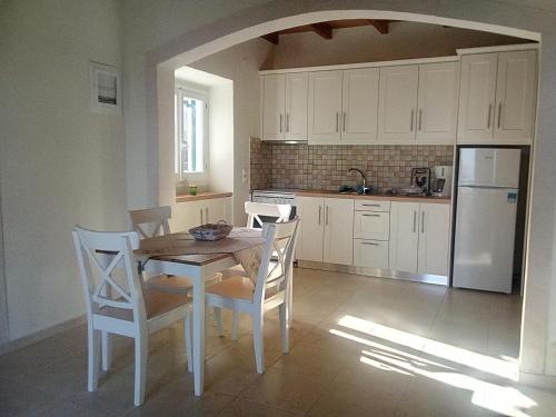 a kitchen with a table and chairs and a refrigerator at Atrium House - Boletsis in Anapaftíria
