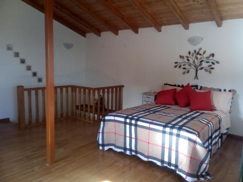 a bedroom with a bed with red pillows at Atrium House - Boletsis in Anapaftíria