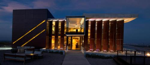 a large building with a lit up facade at night at Casa de Uco Vineyards and Wine Resort in Los Árboles
