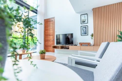 a living room with a couch and a tv at Vmoon villa chiangmai in Chiang Mai