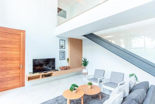 a living room with a couch and a tv at Vmoon villa chiangmai in Chiang Mai