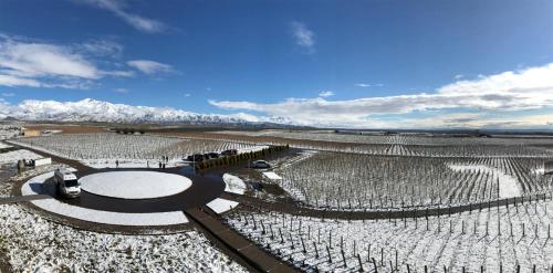 an aerial view of a vineyard with mountains in the background at Casa de Uco Vineyards and Wine Resort in Los Árboles