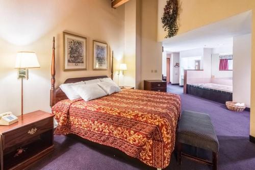 Quality Express Inn & Suites في Mineralwells: غرفة فندقية بسرير كبير وغرفة نوم