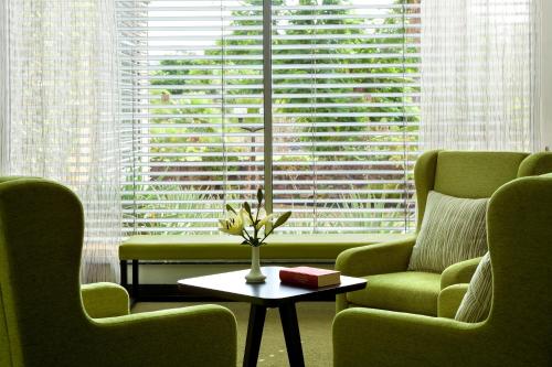 a living room with two chairs and a table in front of a window at Hotel Tigaiga in Puerto de la Cruz