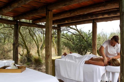 a woman laying on a bed next to a man at Casa de Uco Vineyards and Wine Resort in Los Árboles
