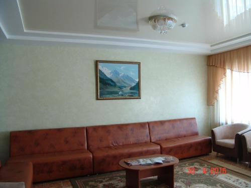 a living room with a couch and a table at Zhaylau Hotel in Shchūchīnsk